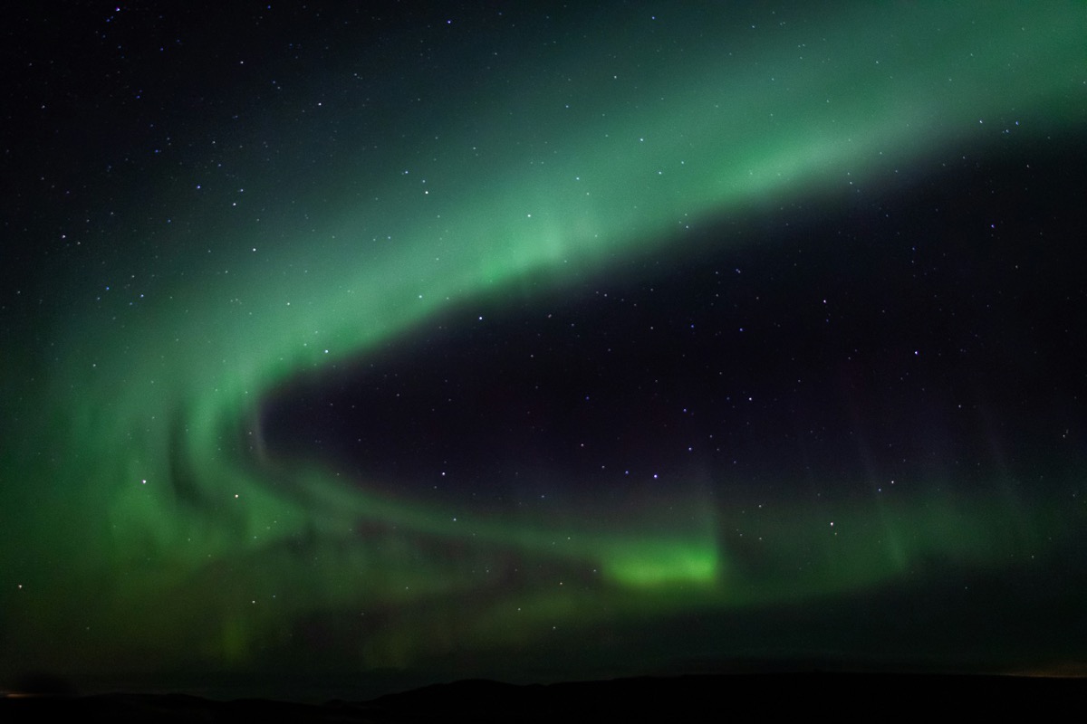 Green aurora borealis across the night sky